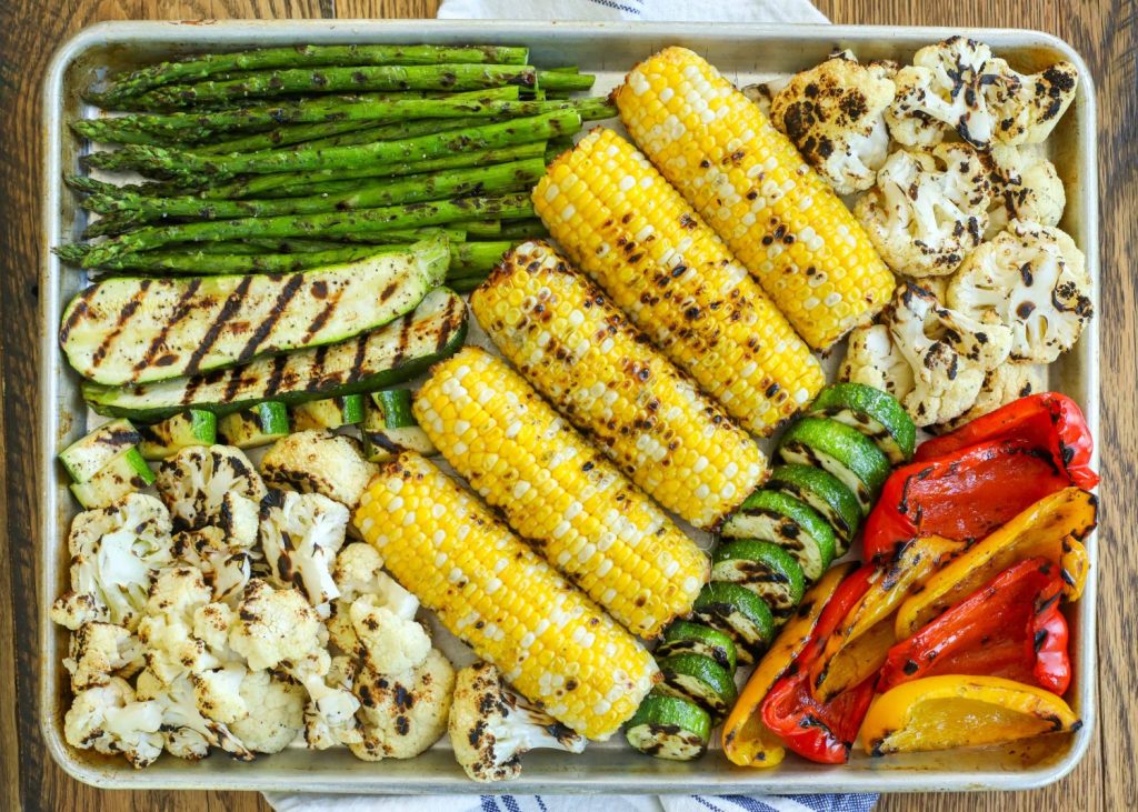 grilled asparagus, squash, corn, cauliflower, and bell peppers on large sheet pan 