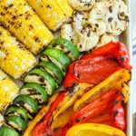 close up of grilled bell peppers, corn, and squash on tray