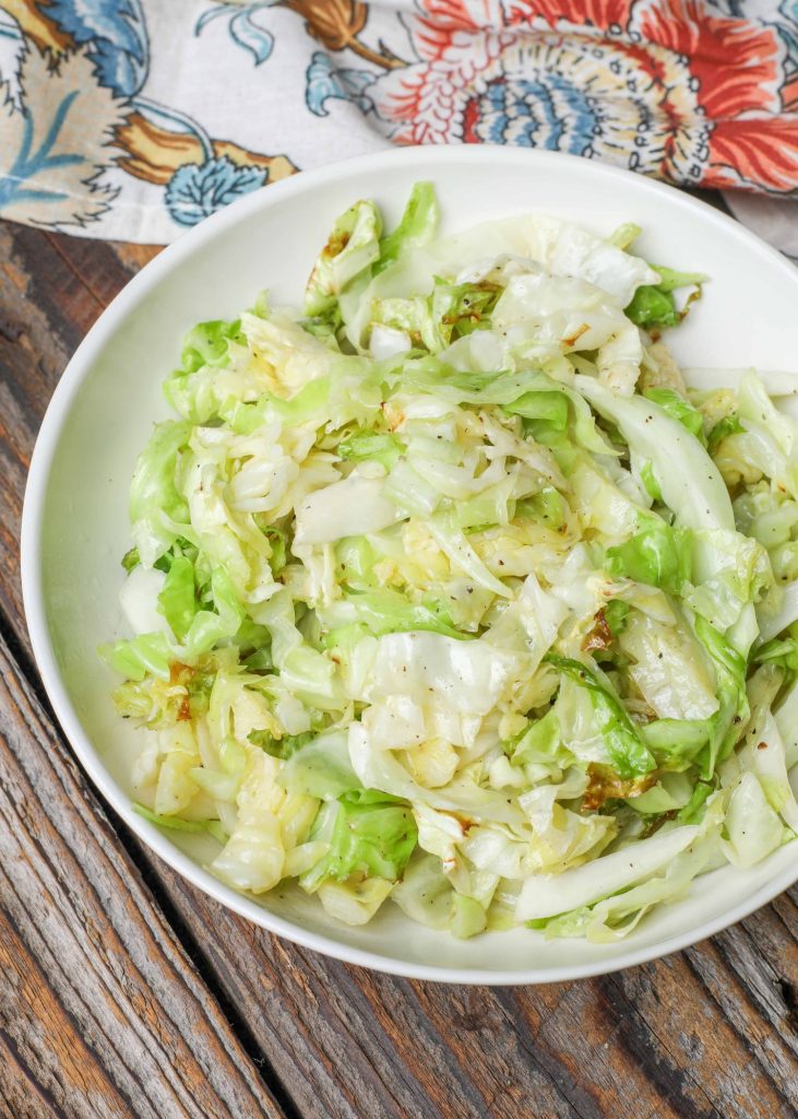 Cooked cabbage in ivory bowl with colorful napkin
