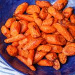 Air Fried Carrots in bright blue bowl with striped towel