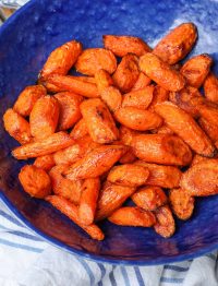 Air Fried Carrots in bright blue bowl with striped towel