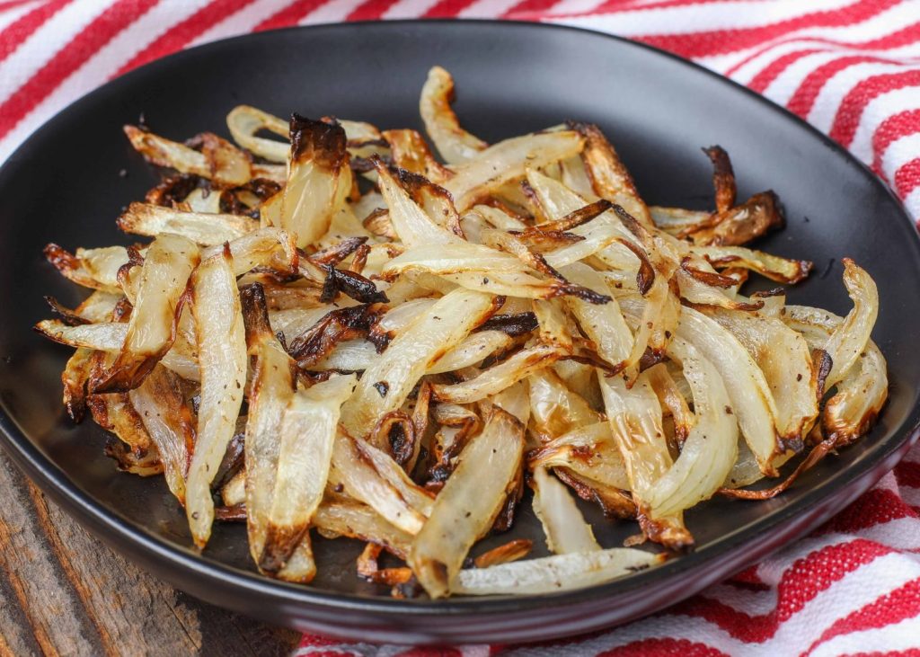 Air fried onions on black plate with red and white napkin