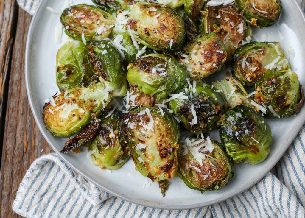 roasted Brussels on grey plate with striped napkin