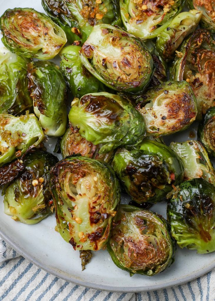 roasted Brussels on plate with grey striped napkin
