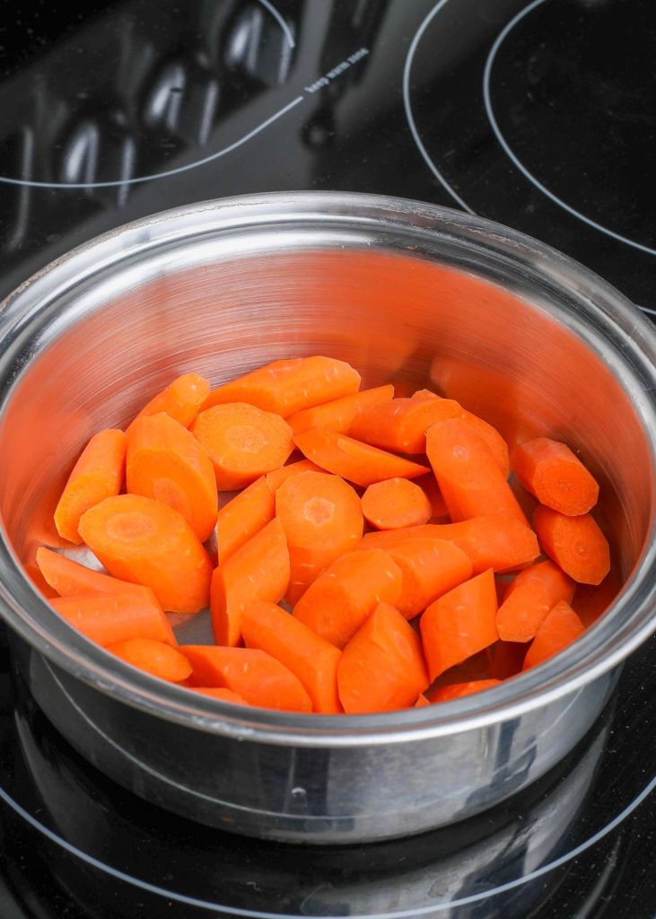 Add the carrots first and bring to a boil along with the water