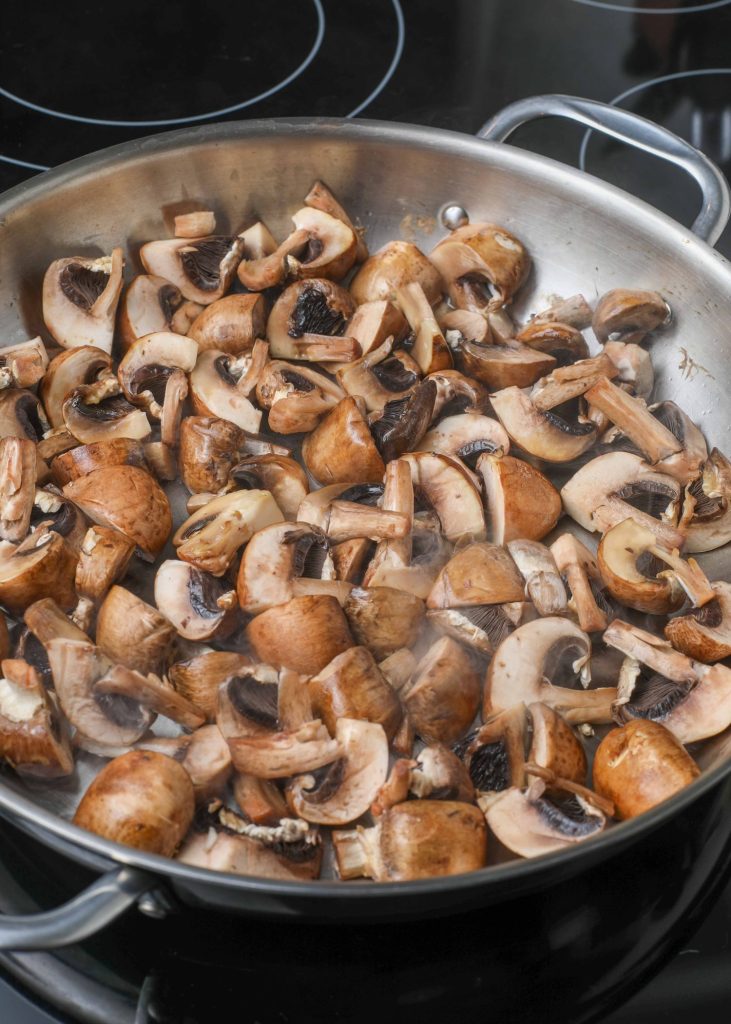Cooking mushrooms in large pan