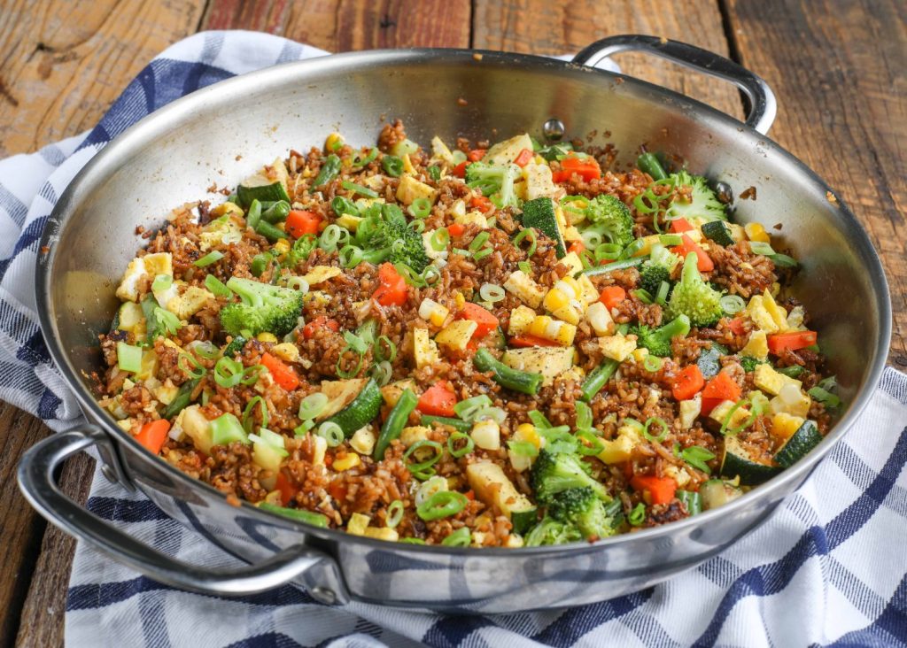 Fried rice with lots of vegetable in large skillet