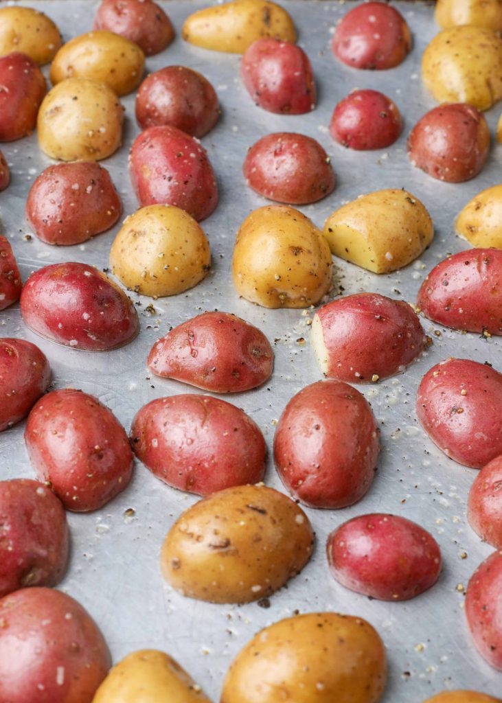 halved baby potatoes on baking sheet