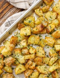 cheese and herb coated roasted potatoes on sheet pan