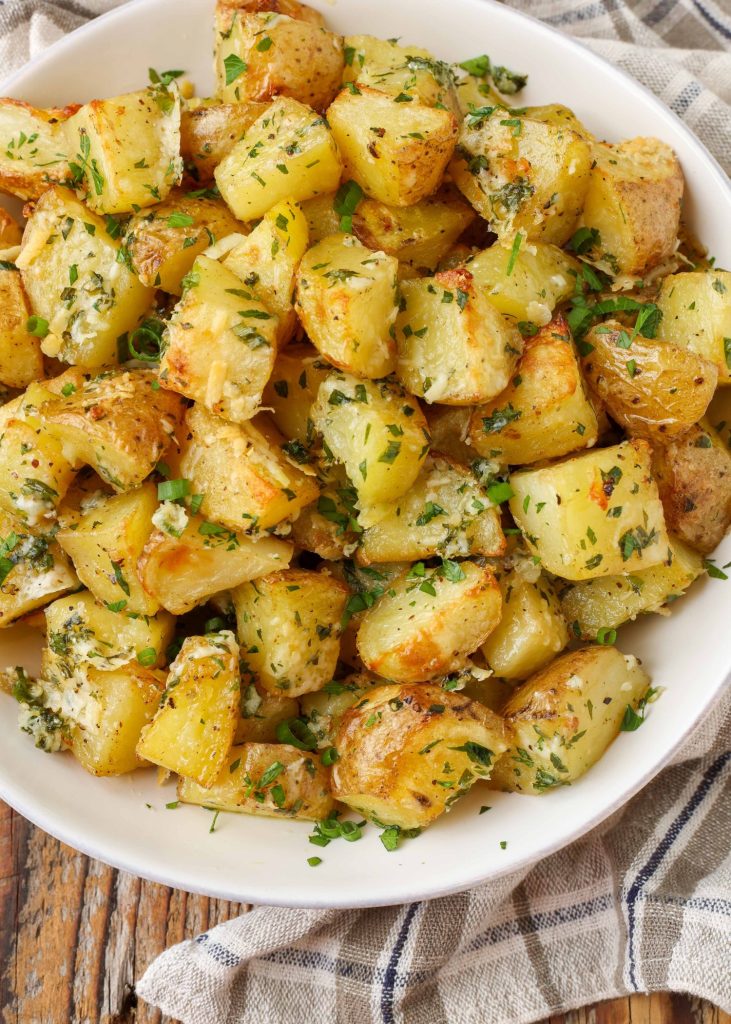 bowl filled with roasted potatoes, cheese, and herbs