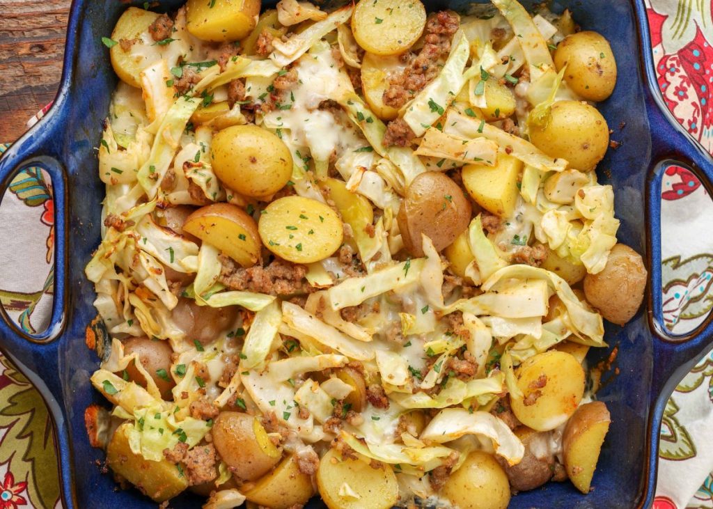 Cabbage with sausage and potatoes in blue baking dish