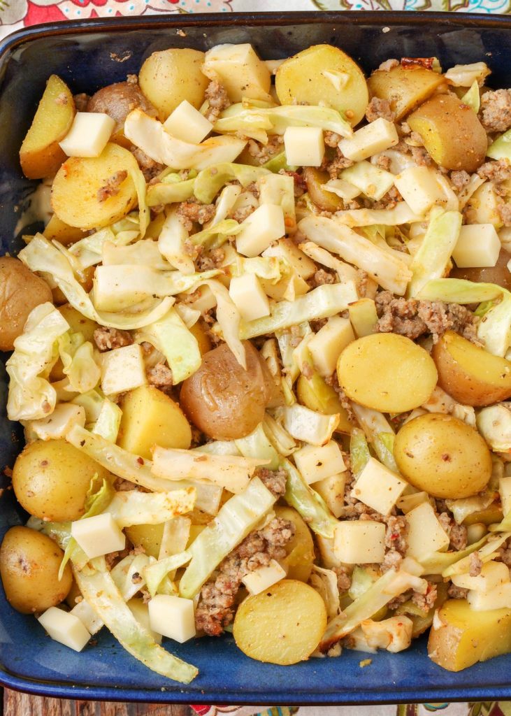 potatoes with sausage and cabbage in blue baking dish