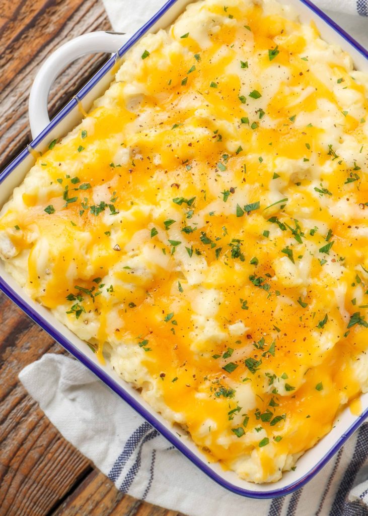 mashed potatoes topped with cheese in square baking dish