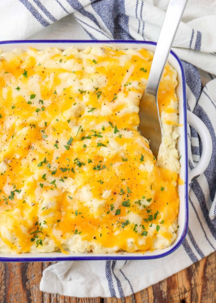 cheese topped mashed potatoes with serving spoon