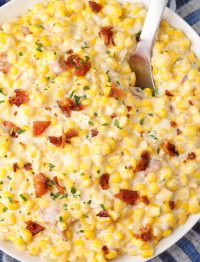 close up shot of corn with bacon in bowl with spoon