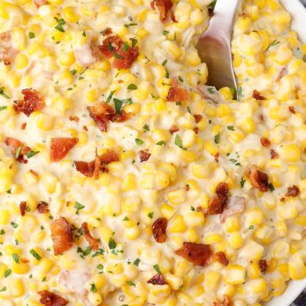 close up shot of corn with bacon in bowl with spoon