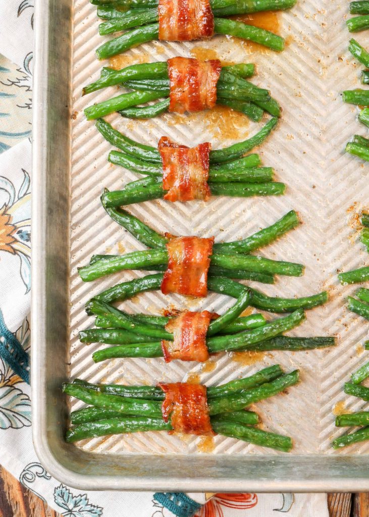 bundles of bacon wrapped green beans on sheet pan