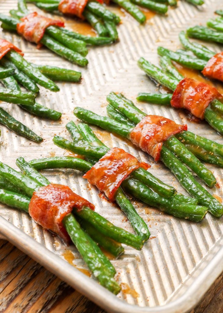 sheet pan with rows of bacon wrapped green beans 