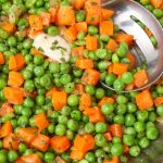 frozen peas and carrots in pan with spoon