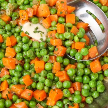 frozen peas and carrots in pan with spoon