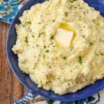 mashed potatoes with butter and parsley in blue bowl