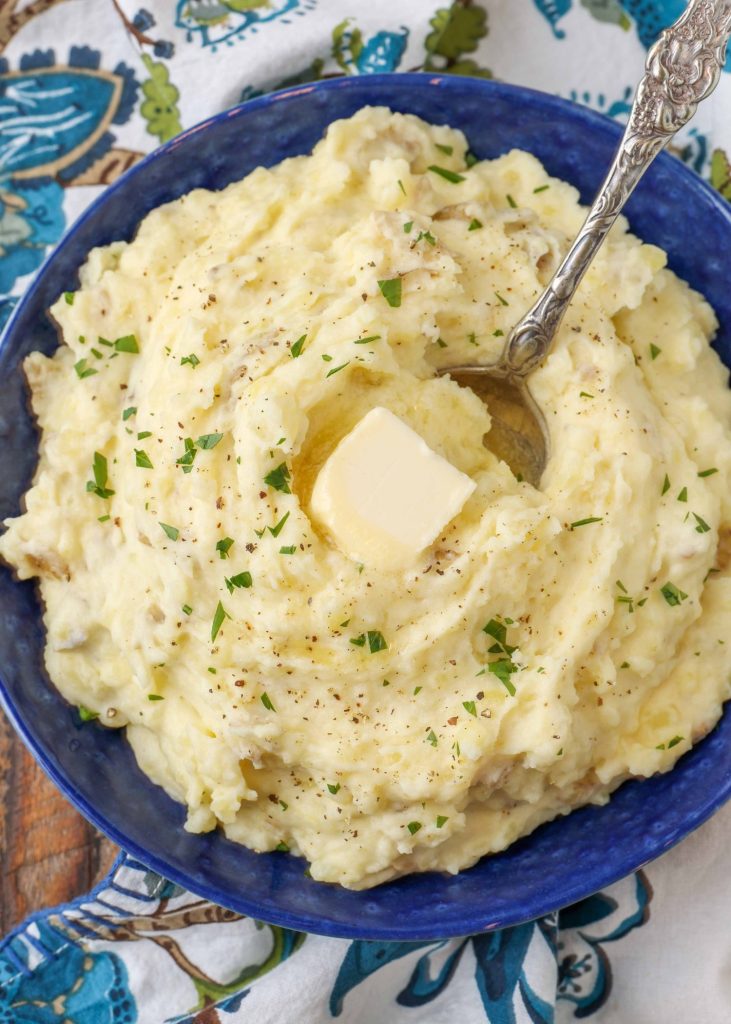 serving dish with mashed potatoes topped with butter
