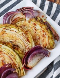 roasted cabbage and onions on platter with black and white towel