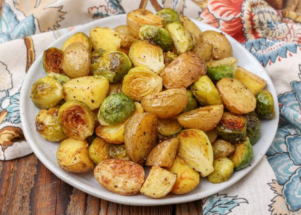 white plate with potatoes and Brussels sprouts on floral napkin