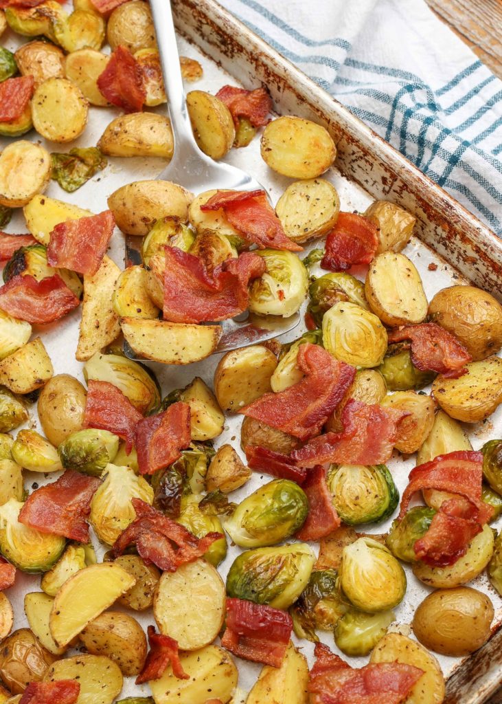 potatoes with bacon and Brussels on sheet pan with spatula