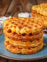 waffles made with corn and bell peppers stacked on blue plate