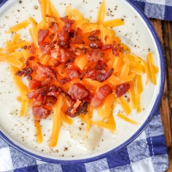 potato soup with cheese and bacon in enamel bowl with napkin