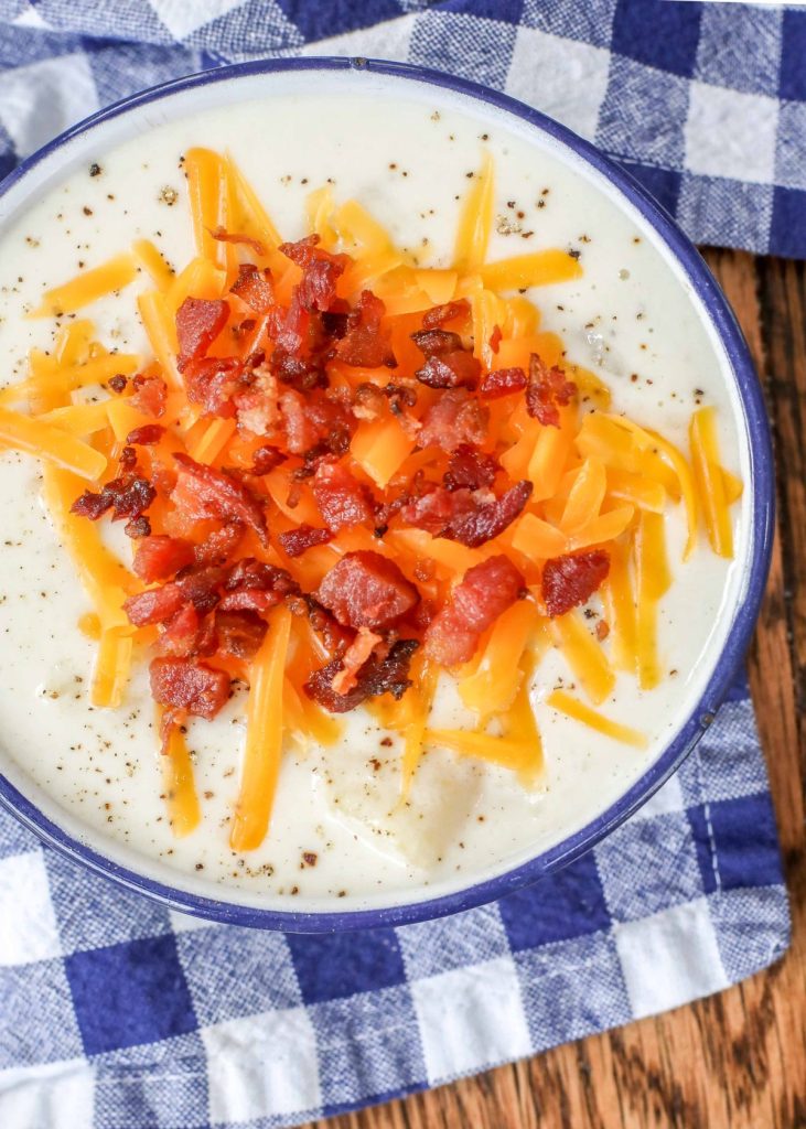 potato soup with cheese and bacon in enamel bowl with napkin