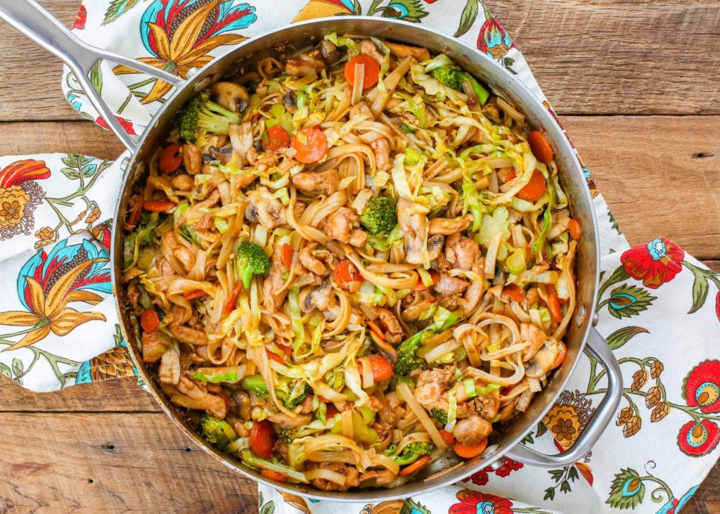 cabbage stir fry with chicken in large skillet with floral napkin
