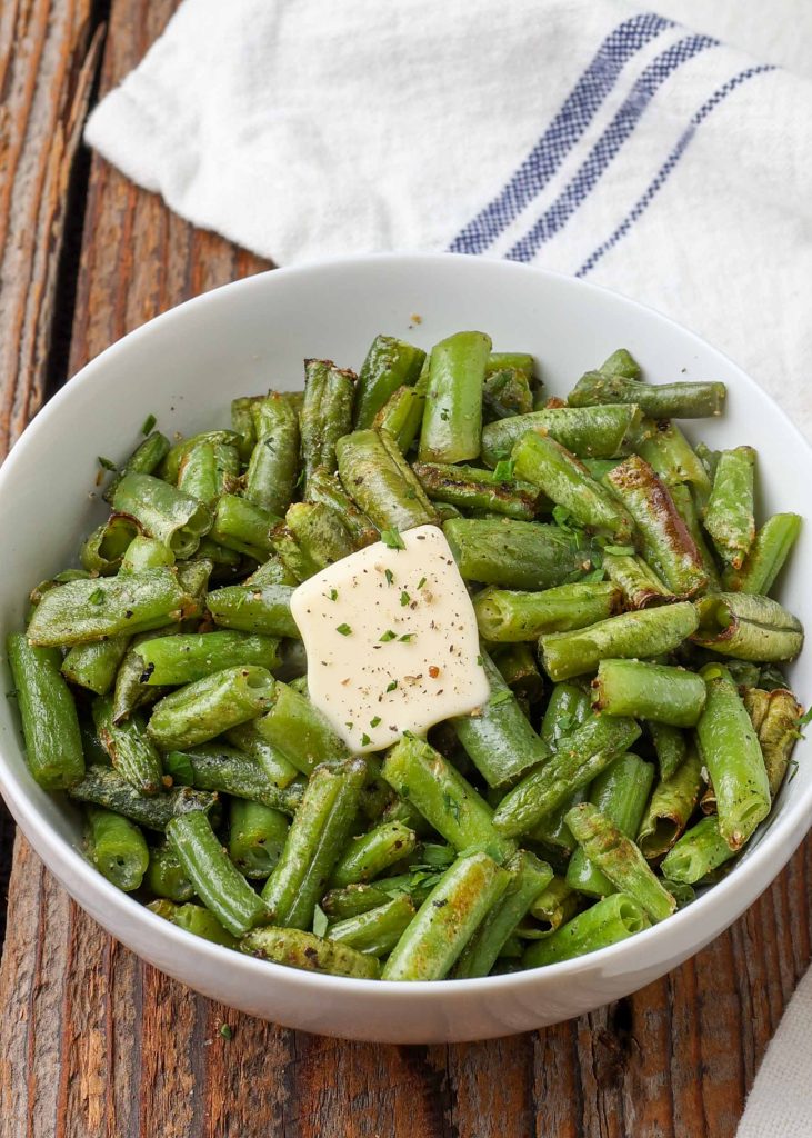 Air Fryer Frozen Green Beans in white bowl with butter