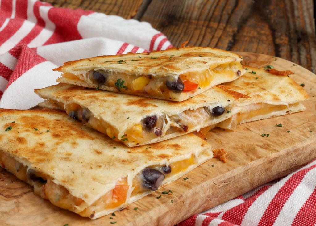 Black Bean Corn Quesadilla on board with red and white towel