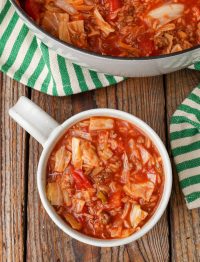 Ground Beef Cabbage Roll Soup in soup mug with green and white towel