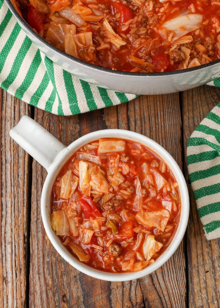 Ground Beef Cabbage Roll Soup in soup mug with green and white towel 
