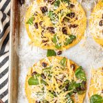 tostada shells layered with cheese, black beans, and spinach before baking