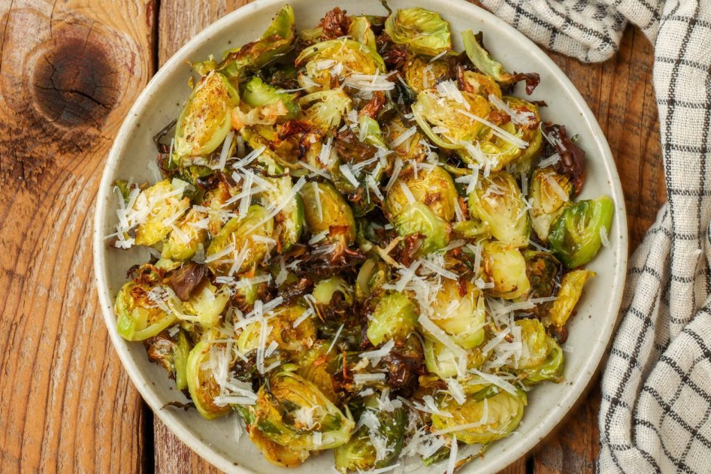 Brussels Sprouts Chips air fried in a white bowl with a towel