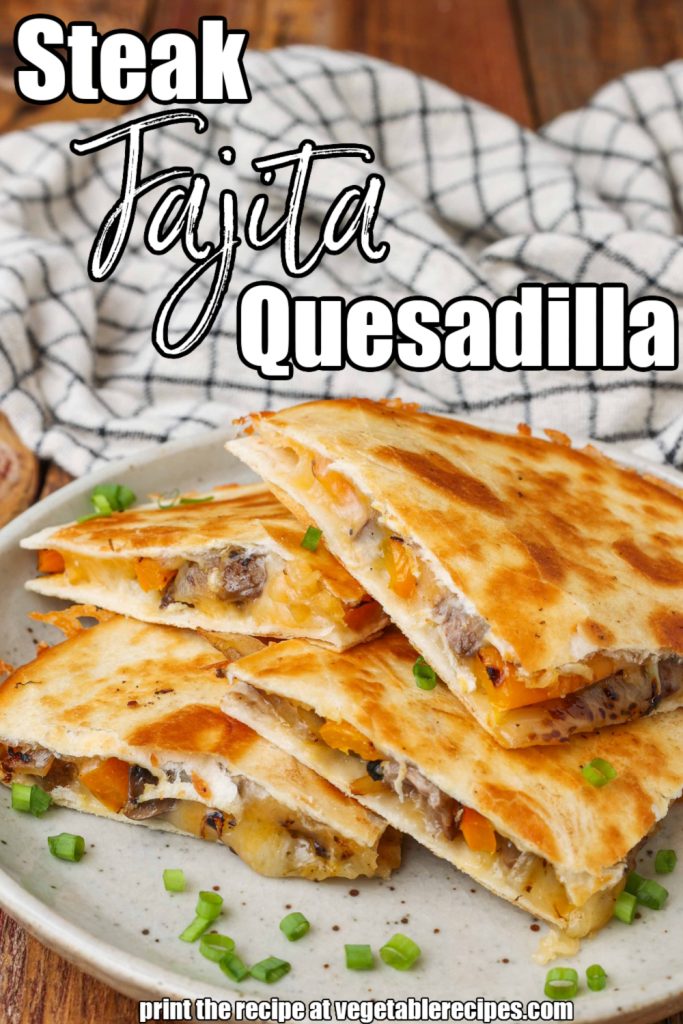 Steak Fajita Quesadilla quartered on white plate with checked cloth