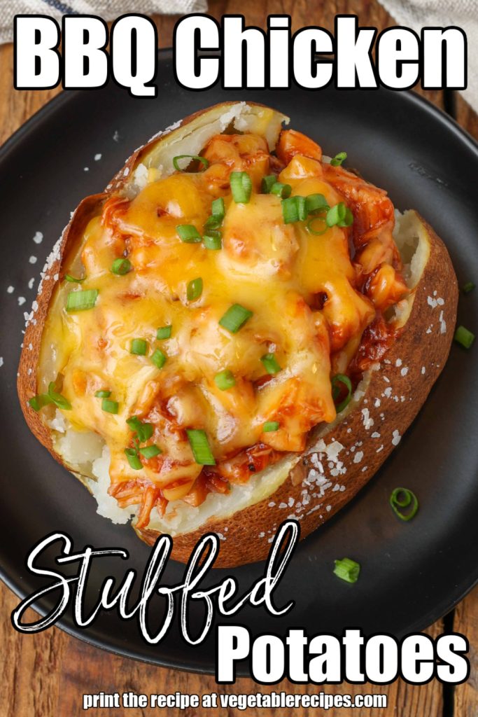 Chicken Stuffed Potatoes smothered in cheese and green onions on black plate