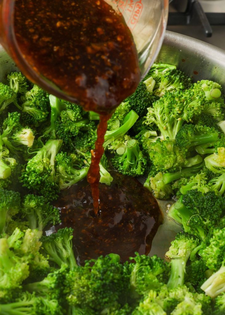 stir fry sauce pouring over beef and broccoli