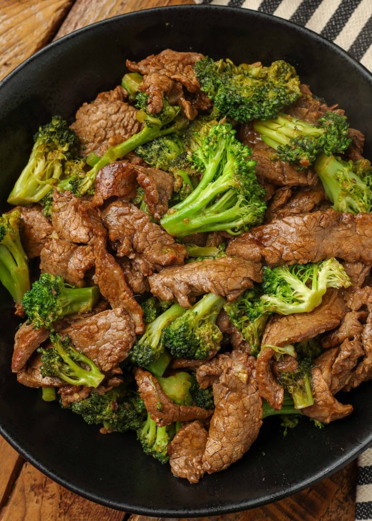beef and broccoli on black plate