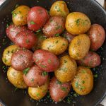 red and yellow baby potatoes in black bowl
