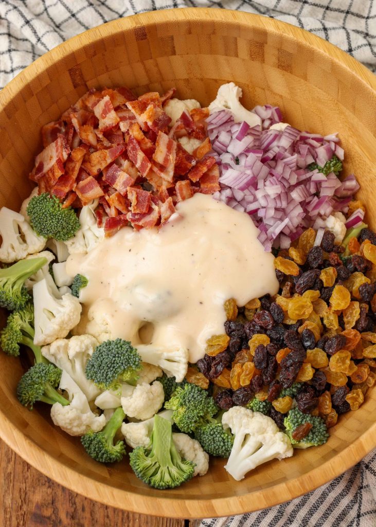 Broccoli Cauliflower Salad in wooden bowl with dressing