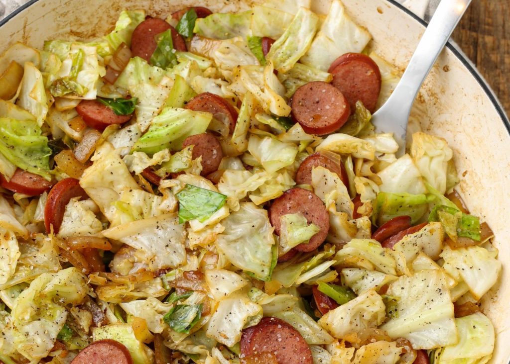 Cabbage and Sausage in white skillet