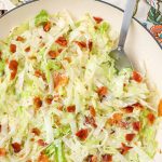 Creamed Cabbage with Bacon in white skillet