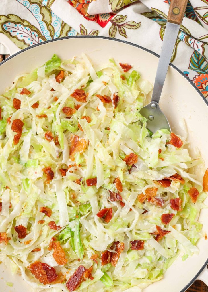 Creamed Cabbage with Bacon in white skillet