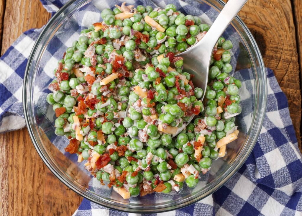 pea salad in mixing bowl with serving spoon