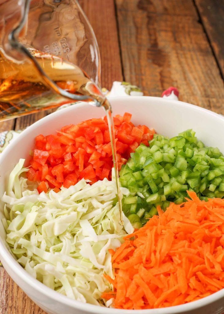 vinaigrette poured over cabbage with bell peppers
